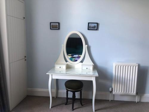 a dressing table with a mirror and a stool at Beautiful Double Room in Idyllic West End Townhouse in Glasgow