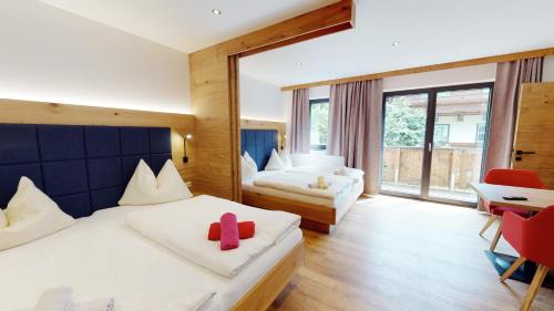 a hotel room with a bed, chair and a window at Pension Lederergütl in Saalbach-Hinterglemm