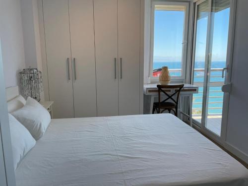 a bedroom with a bed and a desk and a window at La Roca Sea View Apartment in Torremolinos