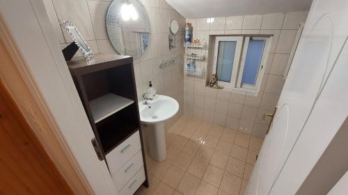 Baño pequeño con lavabo y espejo en WoodHouse, en Markopoulo