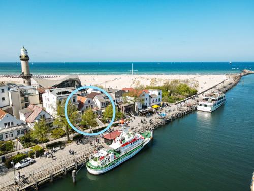 eine Gruppe von Booten, die an einem Pier neben einem Strand angedockt sind in der Unterkunft Kapitaenshaus in Wasserlage! Traumapartments Warnemuende in Warnemünde