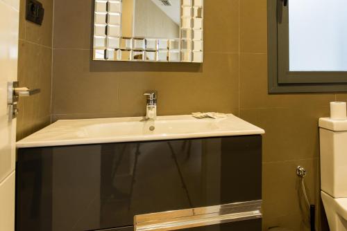 un bagno con lavandino e specchio di AB Apartamentos Museum a Málaga
