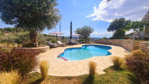 einen Pool in einem Garten mit Stühlen und einem Baum in der Unterkunft Sunny Place Resort Kilada in Kilada
