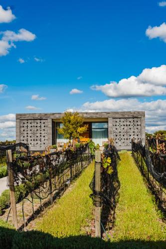 a house with a garden in front of it at Casa Raíces Hotel Luxury & Viñedo in Los Galvanes