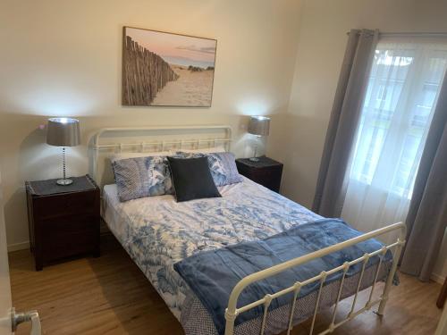 Un dormitorio con una cama con sábanas y almohadas azules. en Elmsford Cottage, en Warragul