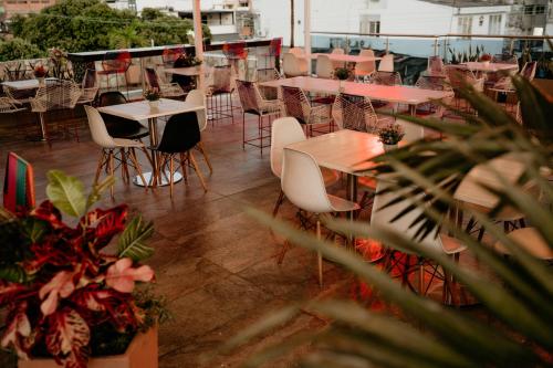 a balcony with tables and chairs and plants at Hotel Barrancabermeja Plaza in Barrancabermeja