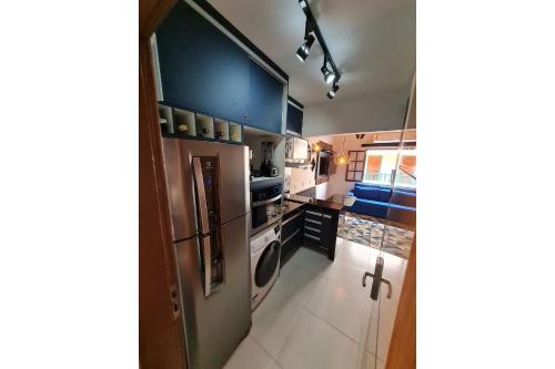 a kitchen with blue cabinets and a washer and dryer at Apto Duplex, Peró - Cabo Frio. Conforto, Piscina, Beira Mar. in Cabo Frio