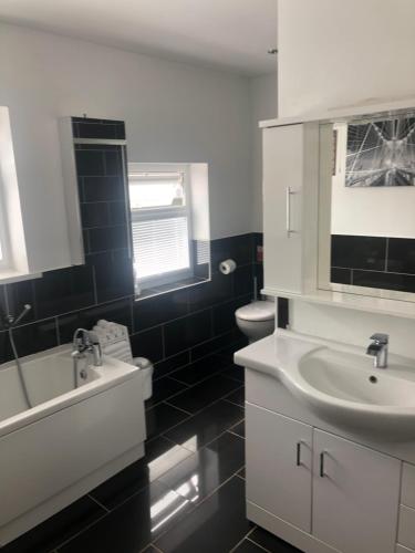 a black and white bathroom with a sink and a toilet at HALLSTEAD in Skegness