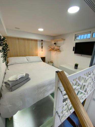 1 dormitorio con cama blanca y balcón en Precioso loft en centro histórico de Melilla en Melilla