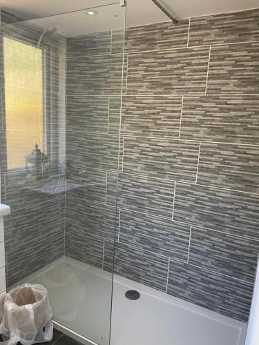 a bathroom with a shower with a glass door at Cabin with Hot Tub in Aberdeenshire in Gamrie