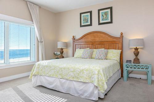 a bedroom with a bed and two lamps and a window at Escapes! To The Shores #204 in Orange Beach