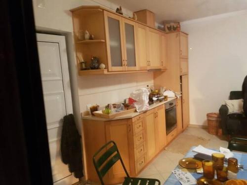 a small kitchen with wooden cabinets and a table and a table at 2-Bedrooms Sleeps 4 10 min drive to Coimbra in Assafarge