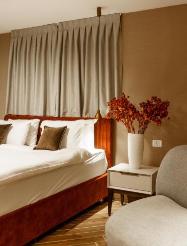 a bedroom with a bed and a vase with flowers on a table at שירת צפת in Safed