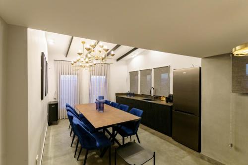 a kitchen and dining room with a table and blue chairs at שירת צפת in Safed