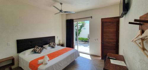 um quarto com uma cama e uma porta de vidro deslizante em Carri Surf Studio em Puerto Escondido