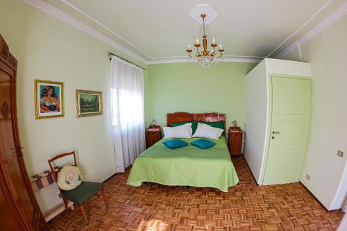 1 dormitorio con cama y lámpara de araña en Villa Delbia - Il Sogno, en Candelo