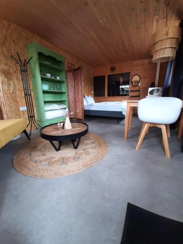 a living room with a table and a bed at Trekkershut De Tulpenweide in Breezand