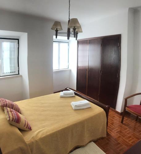 a bedroom with a bed with two towels on it at Costa House in Nazaré
