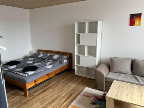 ストジェツにあるApartmán 7のベッド1台とソファが備わる小さな客室です。