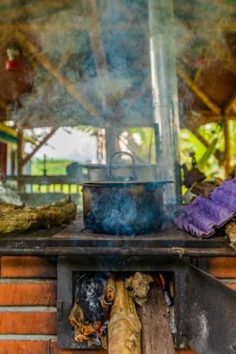 a stove with a pot on top of a fire at Alojamiento Rural Finca El Rubí - Eje Cafetero in Quimbaya