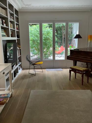 a living room with a piano and a table at MAISON STANDING PROCHE ROLAND GARROS et JO 2024 in Boulogne-Billancourt