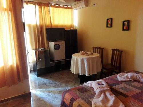 a room with a table and a tv in a room at Complejo Mirador de las Sierras pileta climatizada al aire libre in San Javier