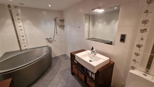 塔林的住宿－Pirita Beach View Suites，带浴缸、水槽和浴缸的浴室