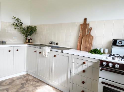 a kitchen with white cabinets and a stove at The Ridge in Burnt Pine