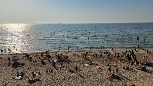 a group of people on the beach at the water at Pirita Beach View Suites in Tallinn