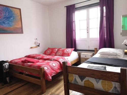 um quarto com 2 camas e uma janela em Hostal Vitalia em Santiago