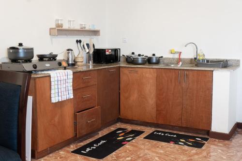 a kitchen with wooden cabinets and a stove at Cozy Penthouse by Hush in Nairobi