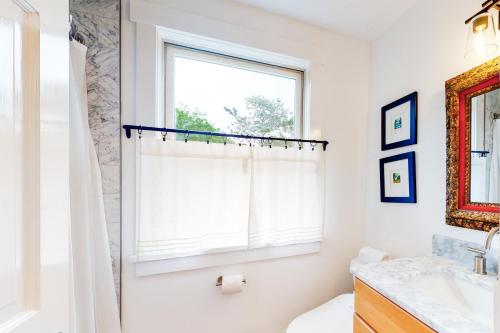 uma casa de banho com uma cortina de chuveiro e uma janela em Sunlit Serenity em West Tisbury