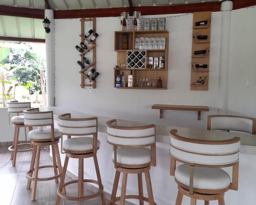 un bar con taburetes de madera en una habitación en Finca Turística La Sofileña, en Guamal