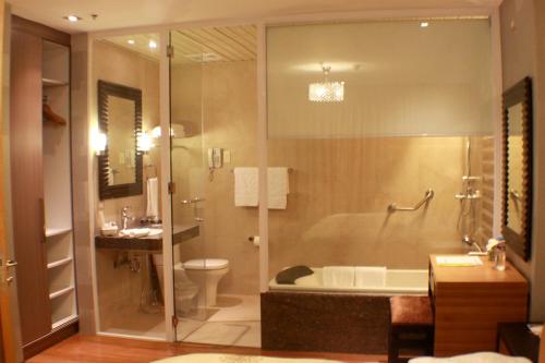 e bagno con vasca, servizi igienici e lavandino. di The Royal Mandaya Hotel a Davao