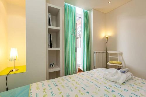 Schlafzimmer mit einem Bett und einem Fenster mit grünen Vorhängen in der Unterkunft Moledo - Listening the Waves in Moledo