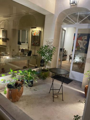 um quarto com uma mesa e vasos de plantas no chão em MAISON STANDING PROCHE ROLAND GARROS et JO 2024 em Boulogne-Billancourt