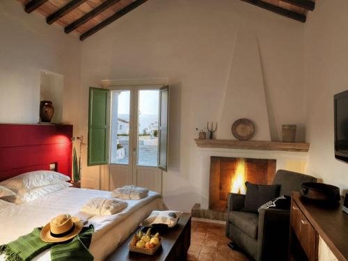 a bedroom with a bed and a couch and a fireplace at Torre Fiore Hotel Masseria in Pisticci