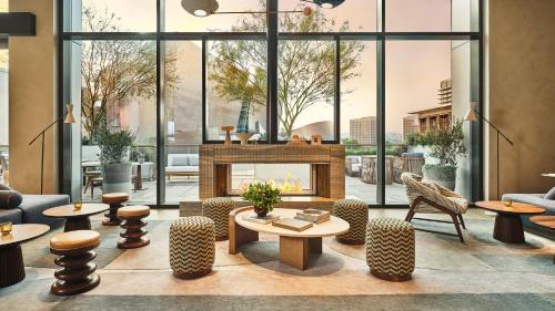 a lobby with a fireplace and tables and chairs at Conrad Los Angeles in Los Angeles