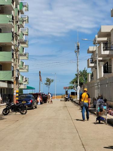 a man walking down a sidewalk next to a building at Rodadero Confort Mar y Sol in Rodadero