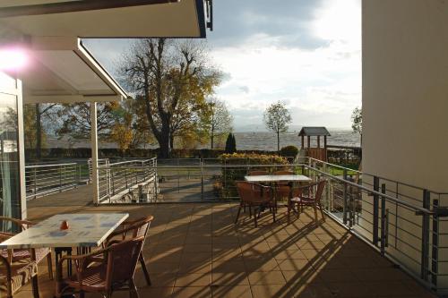 a patio with tables and chairs and a view of the water at CAP Rotach in Friedrichshafen