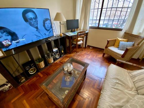 sala de estar con Tv LED y sofá en APARTMENT DOWNTOWN MENDOZA en Mendoza