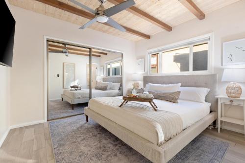 a bedroom with a large bed and a living room at Mission Point 2 by AvantStay Mission Beach Home w Large Balcony Steps to Beach in San Diego