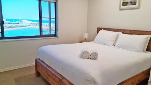 a bedroom with a bed with two slippers on it at Darwin Waterfront Short Stay Apartments in Darwin