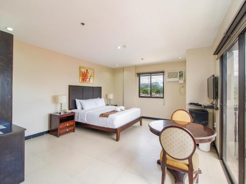 una camera con letto, scrivania e tavolo di Main Hotel & Suites a Cebu City