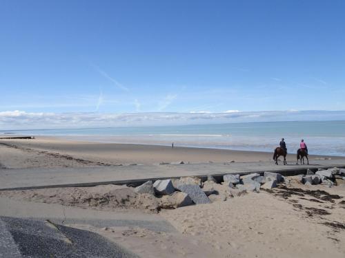 two people are riding horses on the beach at Cottage in Normandy near Barneville-Carteret in Saint-Sauveur-le-Vicomte