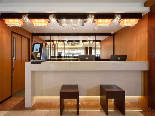 a lobby with a counter with two laptops on it at APA Hotel Haneda Anamori Inari Ekimae in Tokyo
