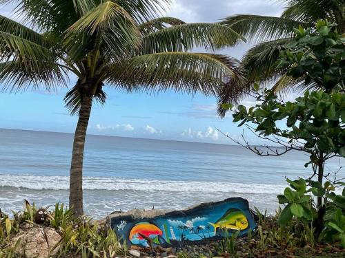un dipinto su una spiaggia con una palma e l'oceano di VILLA SEA BEACH ad Aguada