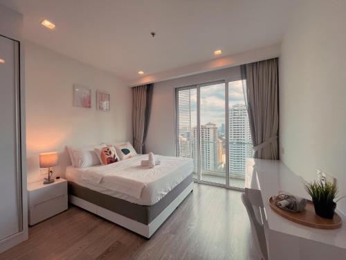 a bedroom with a bed and a large window at LUX SUITES KL City Pavilion Bukit Bintang with INFINITY POOL in Kuala Lumpur