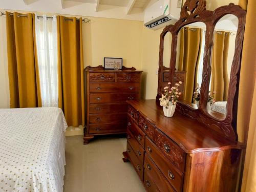 a bedroom with a dresser and a large mirror at L&V Paradise Vacation Home with Pool and Gym in Falmouth