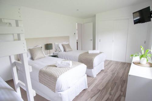 Broadford的住宿－Hickey Vale Farm Lodge Pet Friendly，白色的客房配有两张床和一张沙发